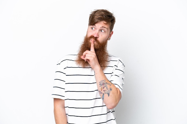 Homme rousse avec barbe isolé sur fond blanc montrant un signe de geste de silence mettant le doigt dans la bouche