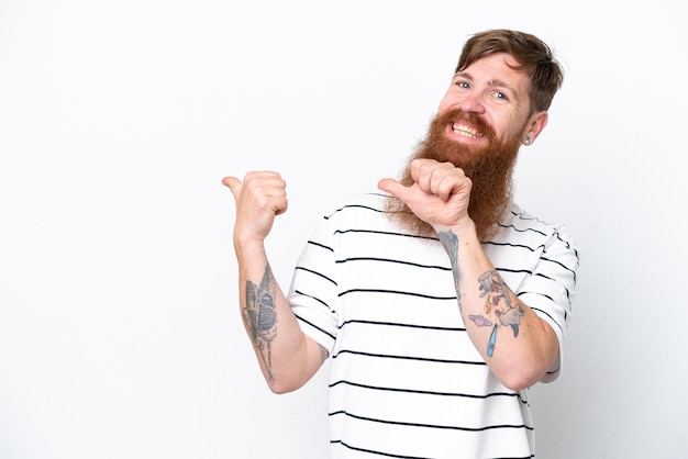 Homme rousse avec barbe isolé sur fond blanc pointant vers le côté pour présenter un produit