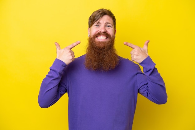 Homme rousse avec barbe isolé sur fond jaune donnant un coup de pouce geste