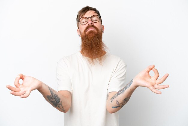 Homme rousse avec une longue barbe isolé sur fond blanc dans une pose zen