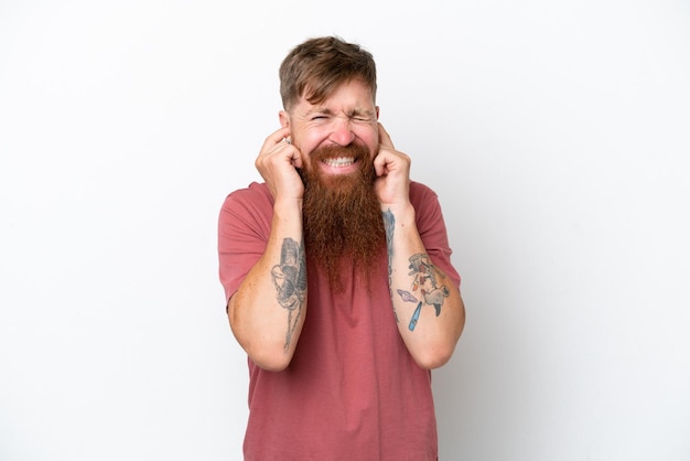 Homme rousse avec une longue barbe isolé sur fond blanc frustré et couvrant les oreilles