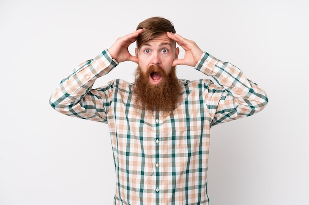 Homme rousse avec longue barbe sur mur blanc isolé avec expression surprise