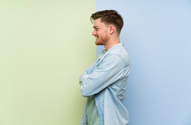 Homme rousse sur mur coloré en position latérale