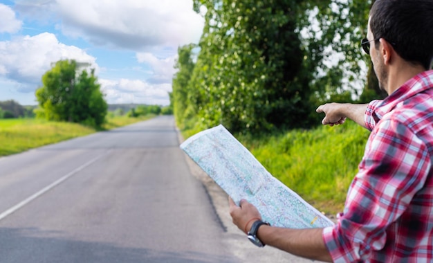 Photo un homme sur la route regarde une carte mise au point sélective