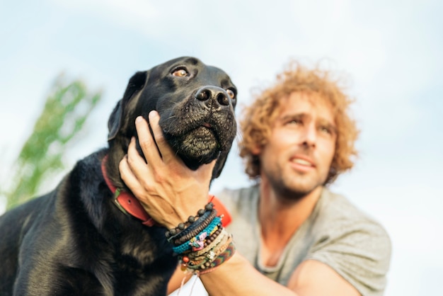 Photo homme s'amusant et jouant avec son chien dans le parc.