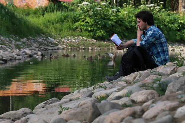 L'homme s'asseoir sur la rivière de pierre