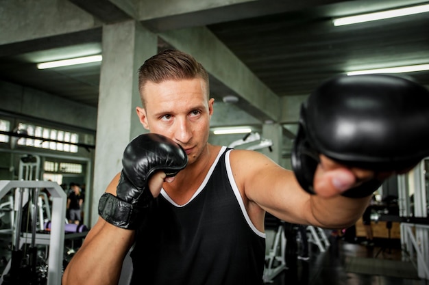 Un homme s'entraîne à la boxe au gymnase.
