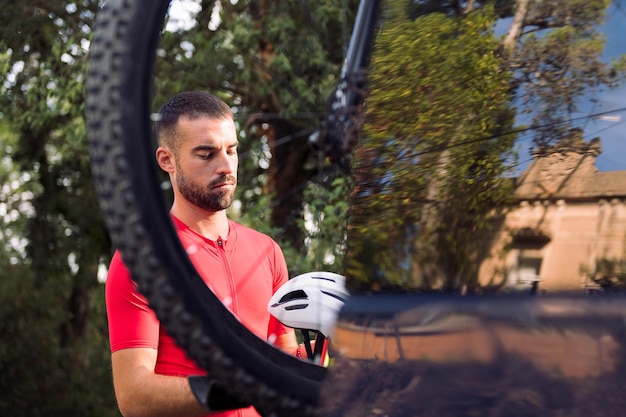 Homme s'habillant à côté de sa camionnette pour faire du vélo