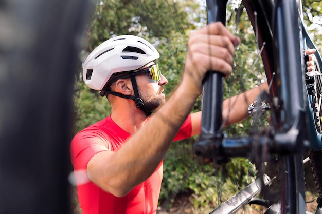 Photo homme s'habillant à côté de sa camionnette pour faire du vélo