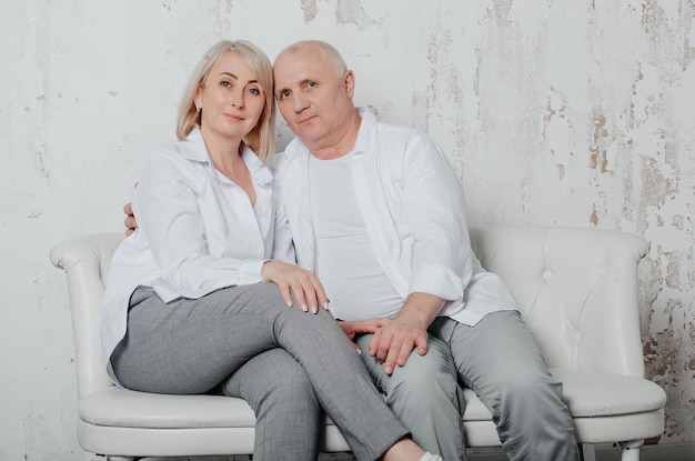 un homme et sa femme en chemises blanches dans un studio photo