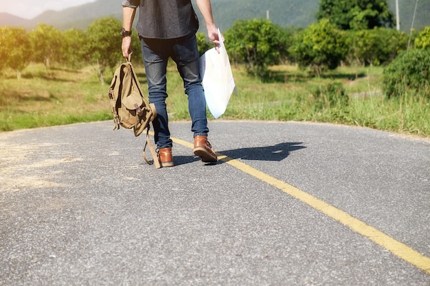 homme avec un sac à bagages à la campagne