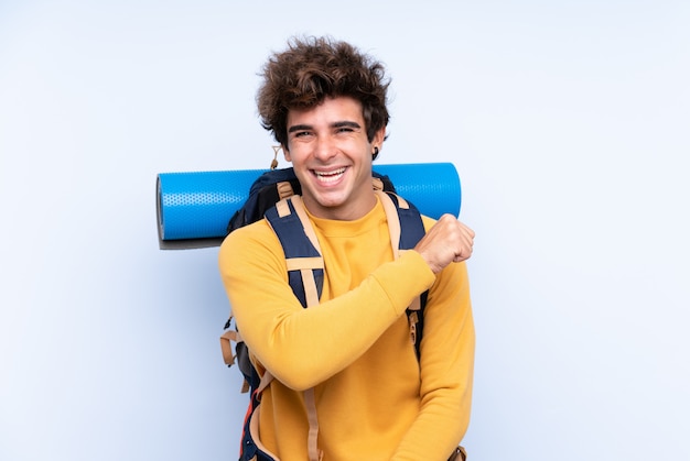 Homme avec sac à dos d'alpiniste sur mur isolé