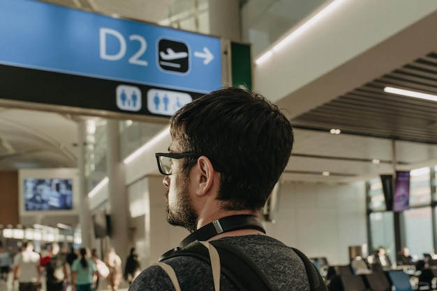 Homme avec sac à dos et casque de musique à l'aéroport