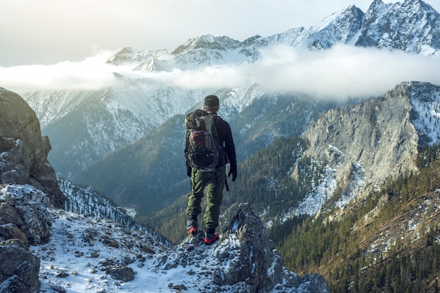 Homme Avec Un Sac à Dos Debout Au Sommet De La Montagne