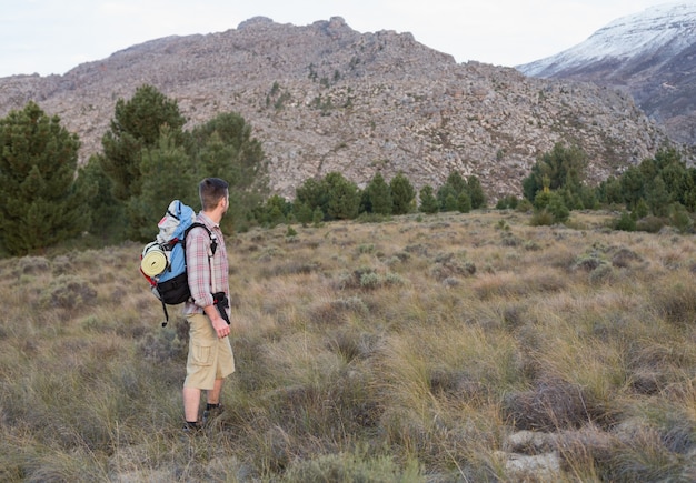 Homme avec sac à dos, debout sur le paysage forestier