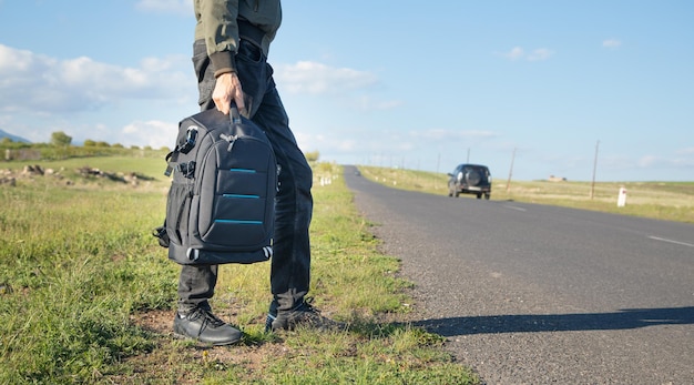 Homme avec sac à dos debout sur la route