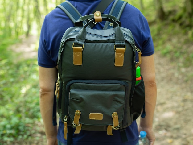 Photo un homme avec un sac à dos sur le dos dans la forêt