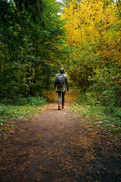 Un homme avec un sac à dos se promène dans l'incroyable forêt d'automne.