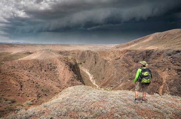 Homme avec sac à dos de voyage dans le désert