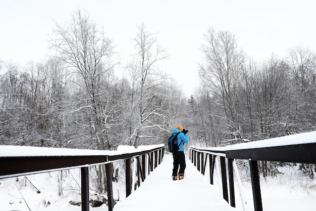 Un homme avec un sac à dos voyage en hiver Un homme dans un champ enneigé Randonnée paysage d'hiver