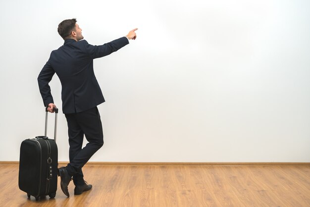 L'homme avec un sac faisant des gestes sur le fond de mur blanc