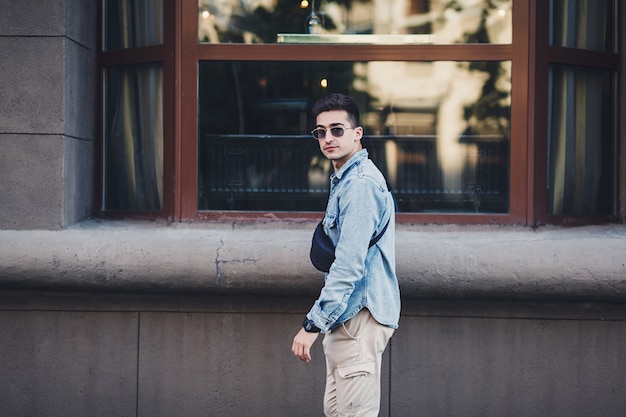 homme avec un sac de vêtements en jean