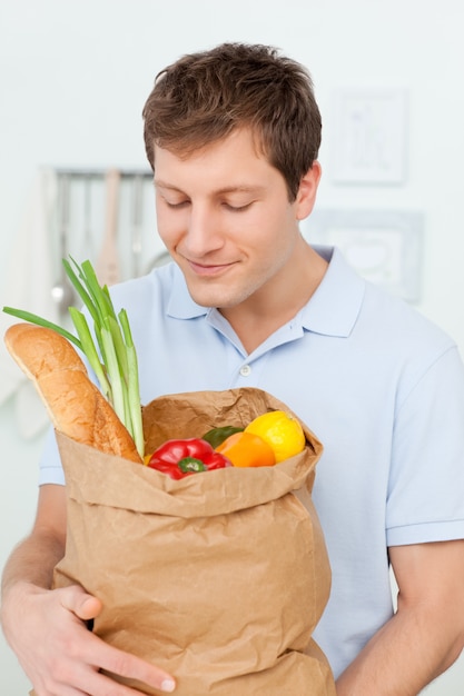 Homme avec des sacs de shopping dans la cuisine