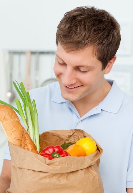 Homme avec des sacs de shopping dans la cuisine