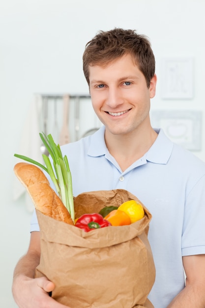 Homme avec des sacs de shopping dans la cuisine