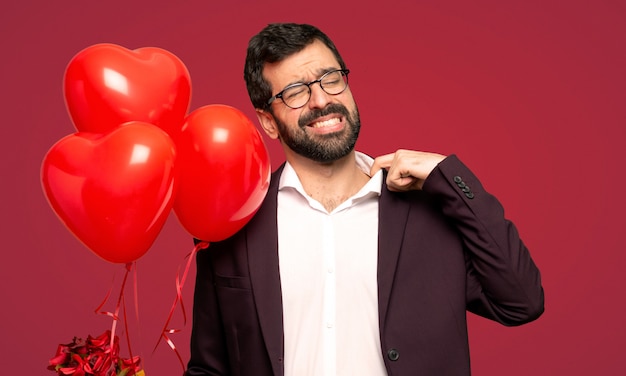 Homme en Saint Valentin avec une expression fatiguée et malade sur fond rouge