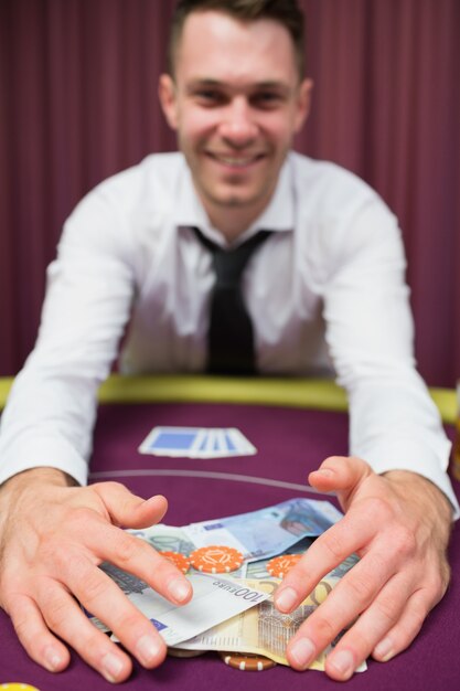 Homme saisissant de l&#39;argent à la table de poker