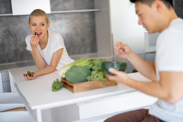 Homme avec salade et fille mangeant des raisins dans la cuisine