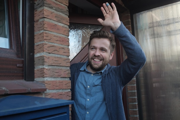 Homme saluant avec un sourire amical et joyeux à ses nouveaux voisins