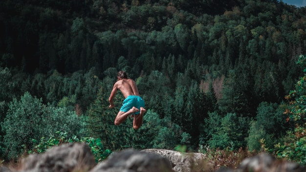 Photo un homme sautant contre les arbres.