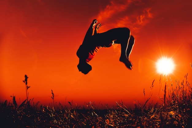 L'homme saute et fait un saut arrière en été dans la nature