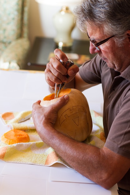 homme sculptant une citrouille