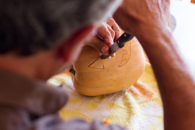 homme sculptant une citrouille