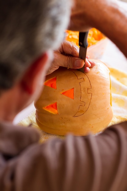 homme sculptant une citrouille