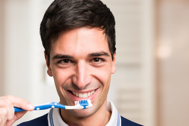 Homme se brosser les dents dans la salle de bain