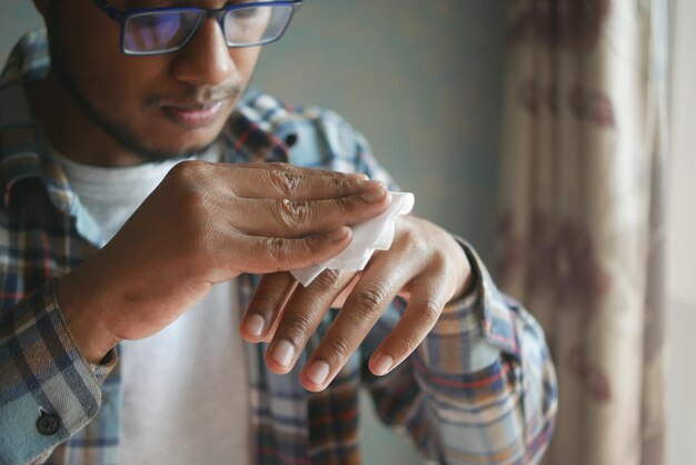 Homme se désinfectant les mains avec une lingette humide