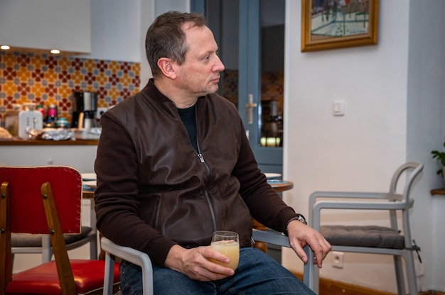 L'homme se détend à la maison et boit un verre d'alcool