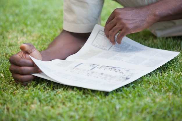 Homme se détendre dans son journal de lecture de jardin