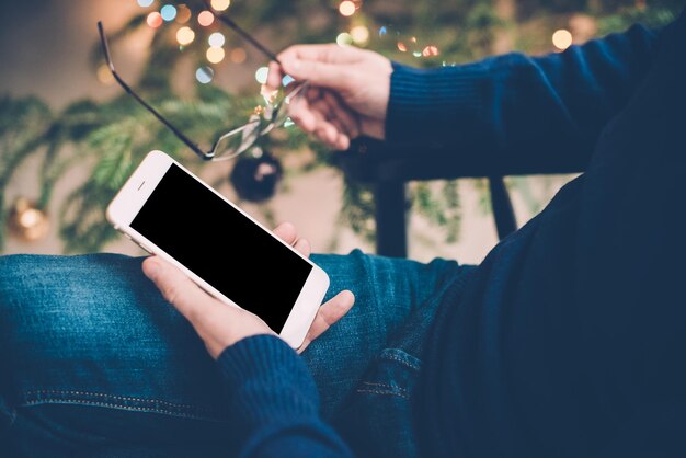 Homme se détendre à la maison avec un smartphone à la main