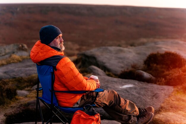 Homme se détendre seul au sommet de la montagne et boire du café chaud Travel Lifestyle concept