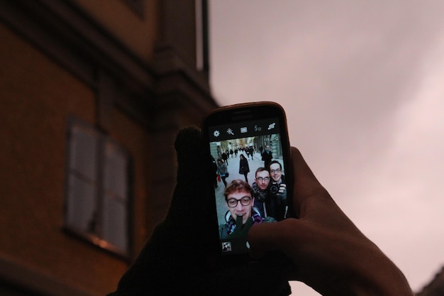Un homme se fait un selfie avec son smartphone.