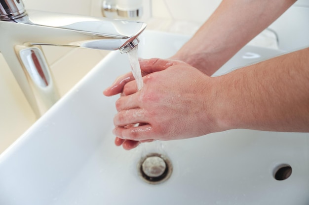 L'homme se lave les mains dans la salle de bain