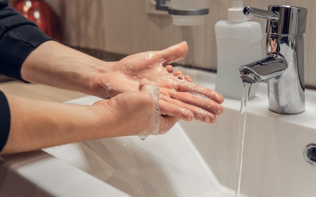 L'homme se lave les mains avec du savon. Fermer