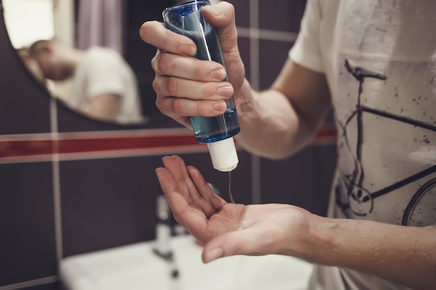 L'homme se lave les mains avec du savon liquide