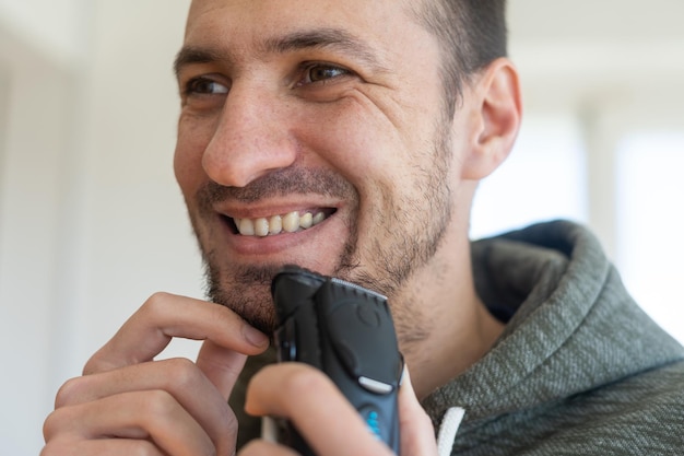 homme se rasant avec un rasoir électrique.