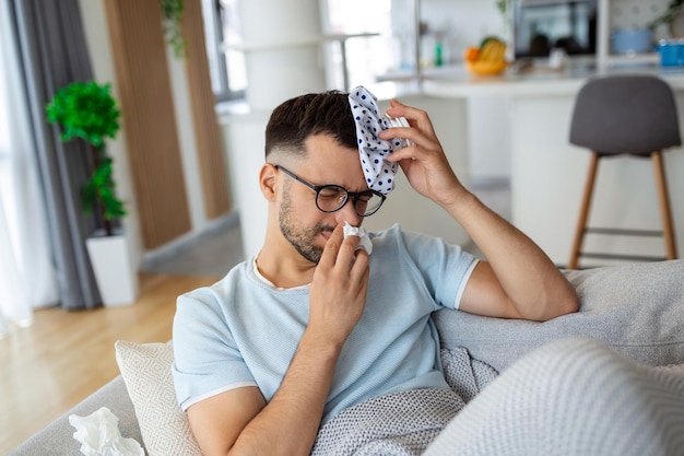 Homme Se Sentant Mal Assis Sur Le Canapé Avec Mal De Tête Et Appliquant Un Sac De Glace